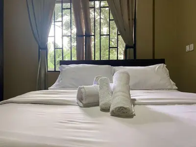 a bed with towels on it with a window at Our Home your Home in Arusha in Nkoanrua