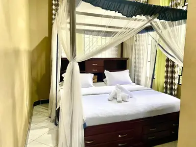 a teddy bear sitting on top of a bed at Our Home your Home in Arusha in Nkoanrua