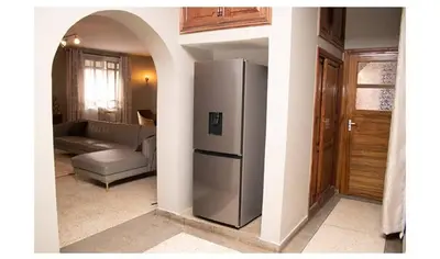 a kitchen with a stainless steel refrigerator in a living room at Asante Home in Arusha
