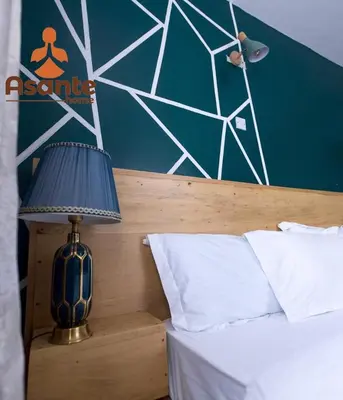 a bedroom with a bed with a blue lamp next to it at Asante Home in Arusha