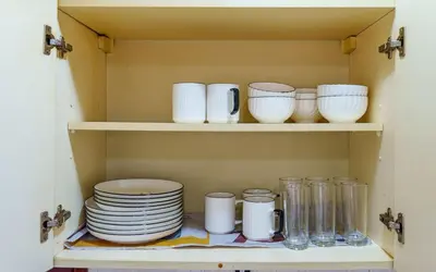 a cupboard with plates and bowls and other dishes at Arusha Urban Haven Homes - Amani Apartment in Arusha
