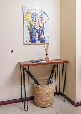 a table in a room with a painting on the wall at Arusha Urban Haven Homes - Amani Apartment in Arusha