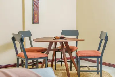 a table with four chairs and a bowl of food on it at Arusha Urban Haven Homes - Amani Apartment in Arusha