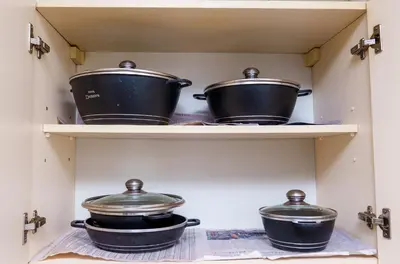 three pots and pans on a shelf in a kitchen at Arusha Urban Haven Homes - Amani Apartment in Arusha