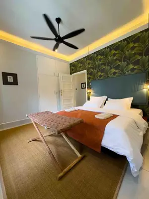 a bedroom with a large bed with a ceiling fan at The Green House in Arusha