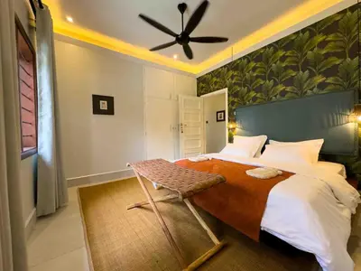 a bedroom with a large bed with a ceiling fan at The Green House in Arusha