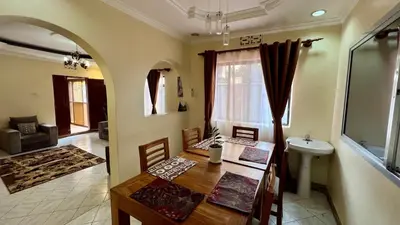 a dining room with a table and a sink in a room at Ultra Home Hostel in Arusha