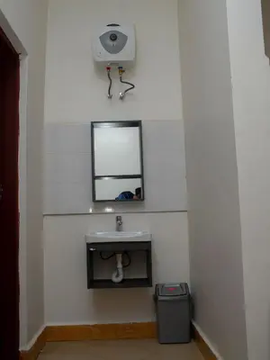 a bathroom with a mirror and a sink at damanda homes in Moshi