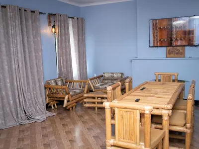 a dining room with a wooden table and chairs at damanda homes in Moshi