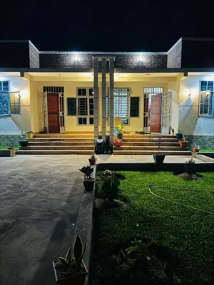 a house with a front porch and stairs at night at kijiji Nest in Usa River
