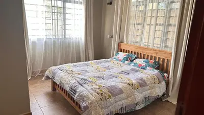 a bedroom with a bed and a window at kijiji Nest in Usa River