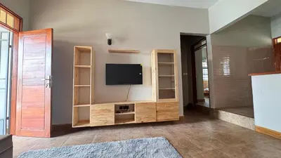 a living room with a tv on a wall at kijiji Nest in Usa River