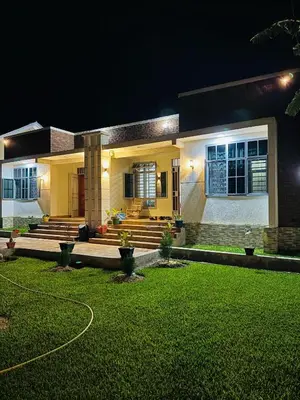 a house with a lawn in front of it at night at kijiji Nest in Usa River