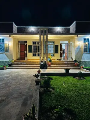 a house with a front porch and stairs at night at kijiji Nest in Usa River