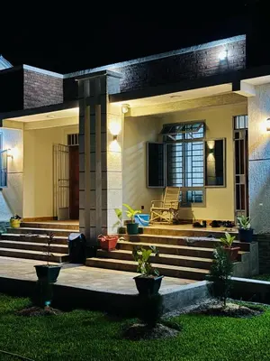 a house with stairs and a porch at night at kijiji Nest in Usa River