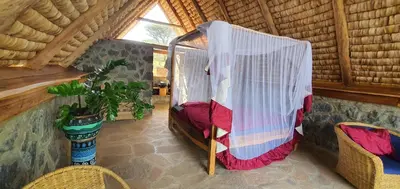 a room with a canopy bed in a cabin at Shamba Pori Lodge in Idulo