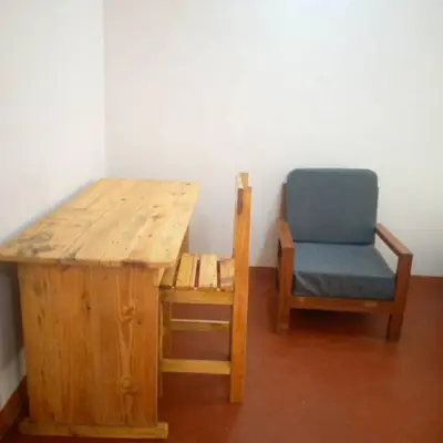 a wooden table and a chair next to a wooden table and a chair at Forest Side Homestay in Moshi