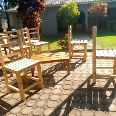 a group of wooden benches sitting on a patio at Forest Side Homestay in Moshi