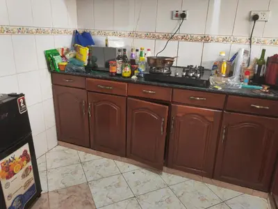 a kitchen with wooden cabinets and a counter top at \u86cb\u7092\u996d\u6c11\u5bbf in Samanga