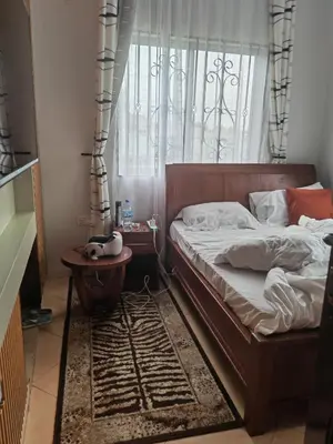 a bedroom with a bed and a table and a window at \u86cb\u7092\u996d\u6c11\u5bbf in Samanga