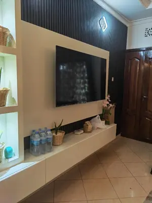 a living room with a large television on a wall at \u86cb\u7092\u996d\u6c11\u5bbf in Samanga