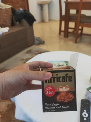 a person holding a box of coffee on a table at \u86cb\u7092\u996d\u6c11\u5bbf in Samanga