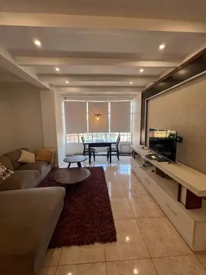 a living room with a couch and a table at Cosy 2 bedroom apartment in Arusha
