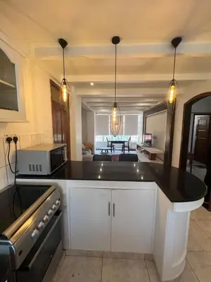a kitchen with a black counter top in a room at Cosy 2 bedroom apartment in Arusha