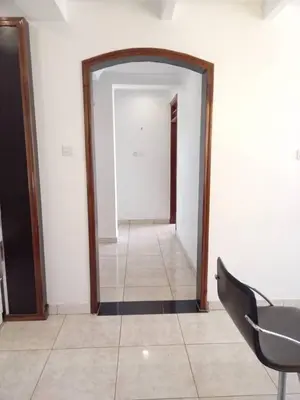 a hallway with a mirror and a chair in a room at Cosy 2 bedroom apartment in Arusha
