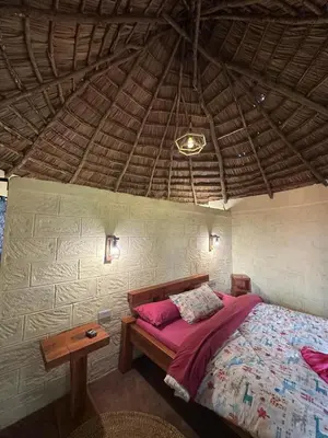 a bedroom with a bed and a wooden table at Mai Kilimanjaro Home Stay in Moshi