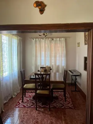 a dining room with a table and chairs and curtains at Kitonga Escape in Msaranga