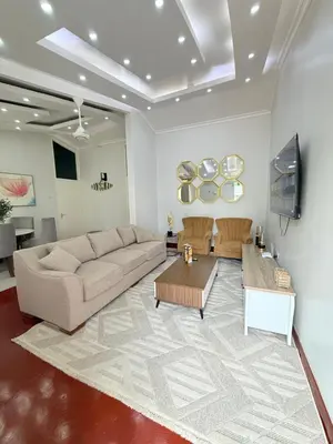 a living room with a couch and a table at Aggiestays - Shanty Town Moshi in Moshi