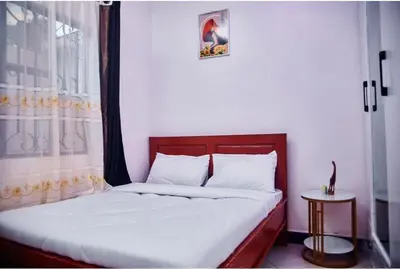 a bedroom with a large bed with a window and a bedskirtspectspectspects at Dema home in Arusha