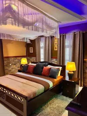 a bedroom with a large bed with two lamps at Meru Havens in Arusha