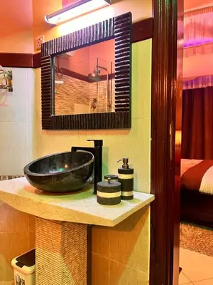 a bathroom with a black sink and a mirror at Meru Havens in Arusha