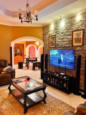 a living room with a flat screen tv on a brick wall at Meru Havens in Arusha