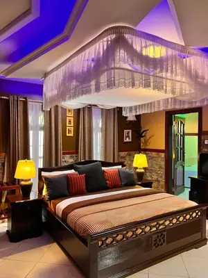 a bedroom with a large bed with a purple ceiling at Meru Havens in Arusha