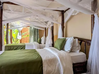a bedroom with two beds and a canopy at Mvuli Mountain Lodge Ngorongoro in Karatu