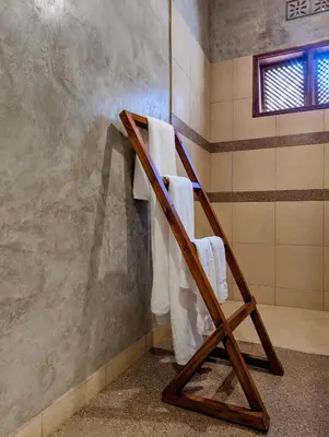 a towel rack in a bathroom with white towels at Mvuli Mountain Lodge Ngorongoro in Karatu