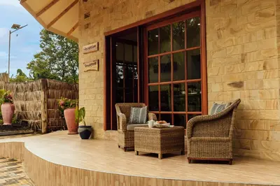 a patio with wicker chairs and a table at Shoki Shoki Lodge Arusha in Arusha