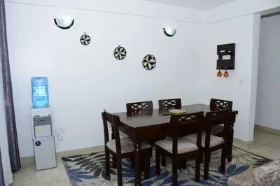 a dining room with a table and chairs and a machine at Newdol homestay Arusha Tanzania in Arusha
