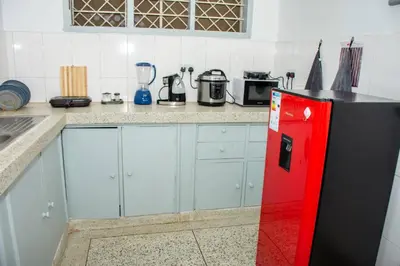 a kitchen with a black and red refrigerator at Newdol homestay Arusha Tanzania in Arusha