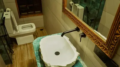 a bathroom with a sink and a mirror and a toilet at Mateves boutique lodge in Arusha