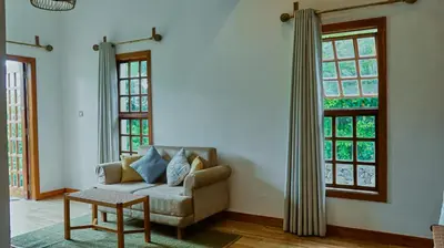 a living room with a couch and two windows at Mateves boutique lodge in Arusha