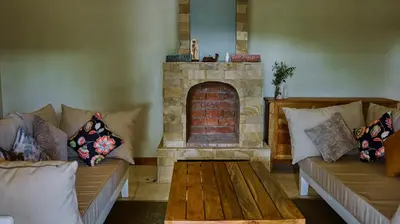 a living room with two couches and a fireplace at Mateves boutique lodge in Arusha