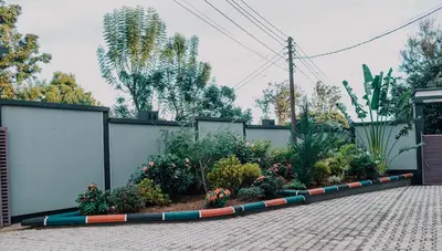 a garden with flowers and plants next to a fence at St Benedict House in Moshi