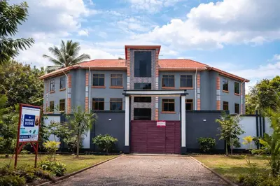 a house with a red door in front of it at St Benedict House in Moshi