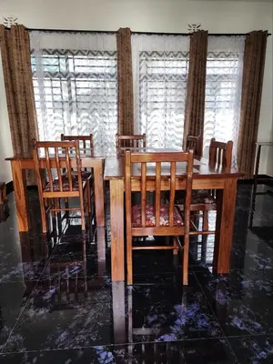 a dining room with a wooden table and chairs at Mimi Home in Arusha