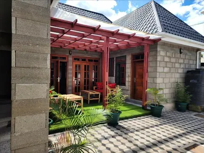 a patio with a red pergola on a house at Mimi Home in Arusha