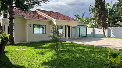 a house with a green lawn in front of it at ENDITO Villas in Arusha